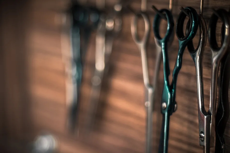 Tijeras de barbero colgadas sobre madera